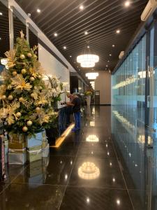 马尼拉Air Residences in the Heart of Makati City - Great for Tourists, Staycations or Working Professionals的坐在大堂桌子上,手持圣诞树的人