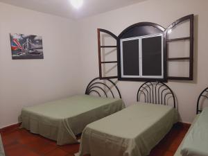 圣代佩德罗Chácara Monteiro - Próximo ao Thermas Water Park的客房设有两张床和窗户。