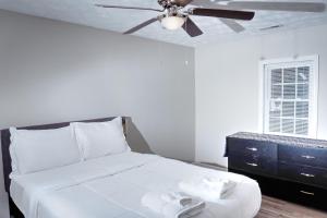 费耶特维尔Brick Beauty Fayetteville 3 bedroom Mins from Downtown的卧室配有白色的床和吊扇