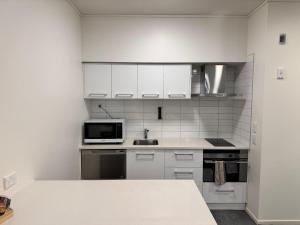 汉密尔顿Zeta Motel的白色的厨房配有水槽和微波炉