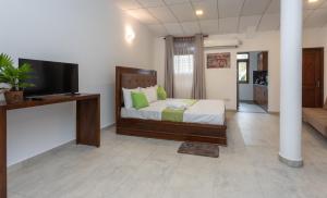 乌纳瓦图纳Villa Windfall Unawatuna的一间卧室配有一张床和一台平面电视