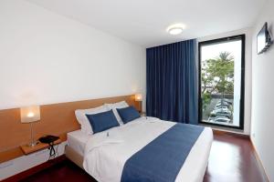 蓬塔德尔加达Thomas Place的一间卧室设有一张大床和大窗户