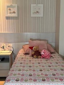 阿奎拉兹Beach Place Resort - Térreo的两只泰迪熊坐在床上