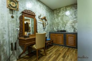 范县Huen San Fang hotel โรงแรมเฮือนแสนฝาง的一间带木制书桌和镜子的浴室