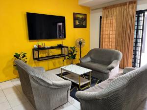 丹那拉打Big Dreams Double Story House的客厅配有椅子和黄色墙壁上的电视