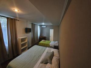 比亚里卡Hotel Villarrica Centro的小房间设有两张床和电视
