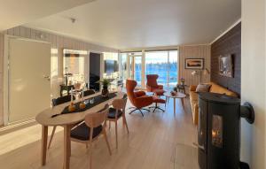 斯朱森Amazing Apartment In Sjusjen With Kitchen的客厅配有桌椅和壁炉
