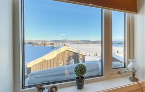 斯朱森Amazing Apartment In Sjusjen With Kitchen的窗户享有雪中建筑的景致