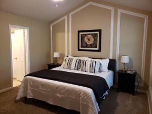 夏洛特Great Getaway Charlotte的一间卧室配有一张大床、两个床头柜和两盏灯。