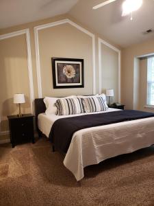 夏洛特Great Getaway Charlotte的一间卧室配有一张大床、两张桌子和两盏灯。