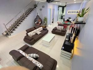 新邦JJ&KK Homestay的一间带棕色沙发和楼梯的客厅