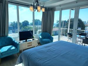 格兰岛Koh Larn Riviera的一间卧室配有一张床、两把椅子和一台电视