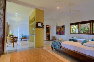 艾湄湾峇都汤加别墅酒店的一间带两张床的卧室和一间客厅