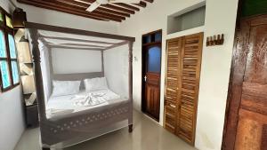 南威Light of Zanzibar Hotel的一间卧室,卧室内配有一张天蓬床