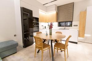 伊西翁BillMar Luxury Apartment in the center of Gythio的厨房以及带木桌和椅子的用餐室。