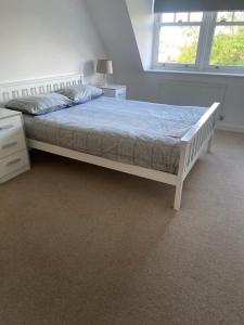 伊灵Lovely 2-bed flat with well equipped kitchen的卧室配有白色的床、书桌和窗户。