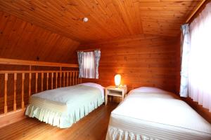神户莫托玉克斯恩卡库日式旅馆的小木屋内一间卧室,配有两张床
