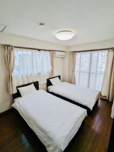 福冈Fieldnever Apartment STAY - Maisonette Family room的配有窗户的客房内的两张床