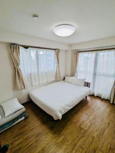 福冈Fieldnever Apartment STAY - Maisonette Family room的卧室设有白色大床和窗户。