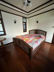 清迈SJ House的一间卧室配有一张带五颜六色棉被的床