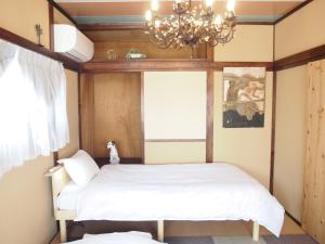 高松Classy仏生山的一间卧室配有一张床和一个吊灯