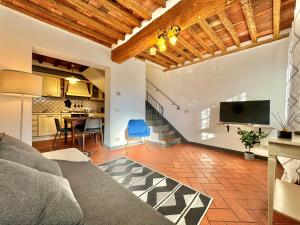 卢卡FRONTE MURA LUCCA - Parcheggio - WiFi Il CORTIGIANO的带沙发和电视的客厅以及厨房。