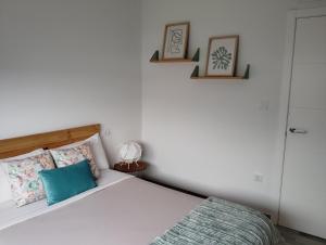 庞特维德拉Apartamento Ría de Vigo的卧室配有一张床,墙上挂有两张照片