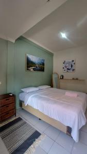庞岸达兰Sea La Vie的卧室配有一张大床,墙上挂有绘画作品