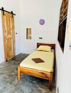 OuidahAmistad的卧室,卧室配有一张床,卧室位于带门的房间