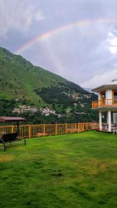 斯瓦特The Swat House的天上一带院子的房子上的彩虹