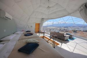 富士河口湖Glamping Dome YOSHIMURA的带大窗户的客房内的两张床