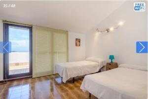 罗列特海岸Casa Mendi en Lloret de Mar的客房设有两张床和大窗户。