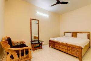 巴特那OYO Hotel Umrao的一间卧室配有一张床、镜子和椅子