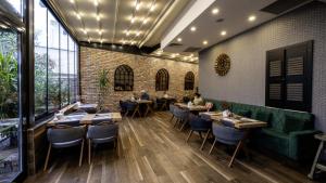 安塔利亚Mai İnci Otel的一间设有桌椅的用餐室和砖墙