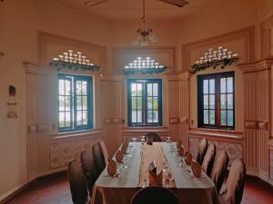 库鲁内格勒Grand Colonial Viveka的一张长桌,房间带椅子和窗户
