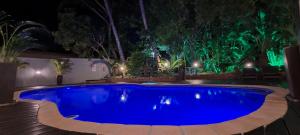 圣卢西亚Leopard Tree Lodge的夜间在院子里的大型蓝色游泳池