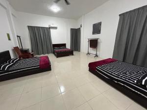 大港Homestay De' Afraa Sungai Besar IslamFriendly的一间设有两张床和一台电视的房间