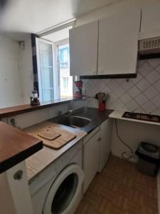 欧里亚克T1 bis centre ville d'Aurillac的厨房配有水槽和洗衣机