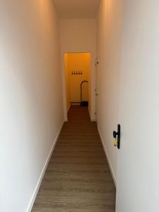 马斯特里赫特luxe pas gerenoveerd monumentaal appartement的走廊设有2扇黄色门,铺有木地板