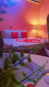 瓦加杜古AG HOTEL Ouaga的一间卧室配有红色和白色枕头的床
