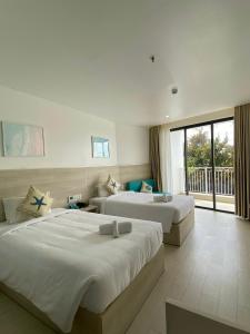 富国HAYA Sea View Hotel Phu Quoc的酒店客房设有两张床和一个阳台。