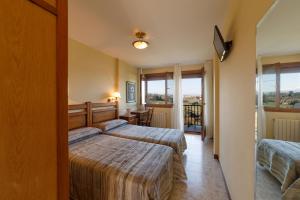 TrasviaEl Mirador de Trasvia Comillas的酒店客房设有两张床和一个阳台。