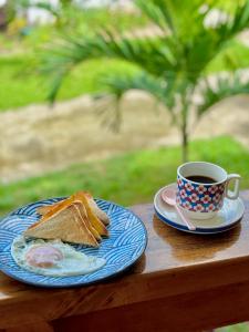 ItaytayLUZVILLE Transient House - Port Barton的夹三明治和咖啡的盘子