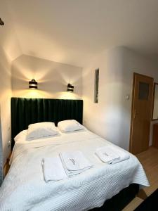BralinMotel Za Miedzą的卧室配有一张白色大床和两条毛巾