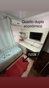 伊瓜苏Quarto Deluxe em Foz piscina wifi estacionamento cozinha E AR的一间配备有一张书桌的房间,电脑在里面