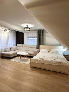 BralinMotel Za Miedzą的一间卧室配有一张床、一张沙发和一张桌子