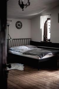 宇格维斯Markowy Dom的卧室配有一张床,墙上挂着一个钟