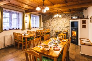 捷克克鲁姆洛夫Pension Krumau的用餐室配有木桌、椅子和壁炉