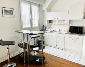 圣阿韦尔坦Charmant appartement en bord de Cher的厨房配有白色橱柜和桌子