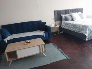 比勒陀利亚Comfy spacious apartment的客厅配有蓝色的沙发和床。